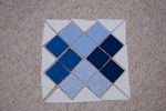Připravte se bílé a modré trojúhelníky a čtverce a seskládejte do konečného tvaru